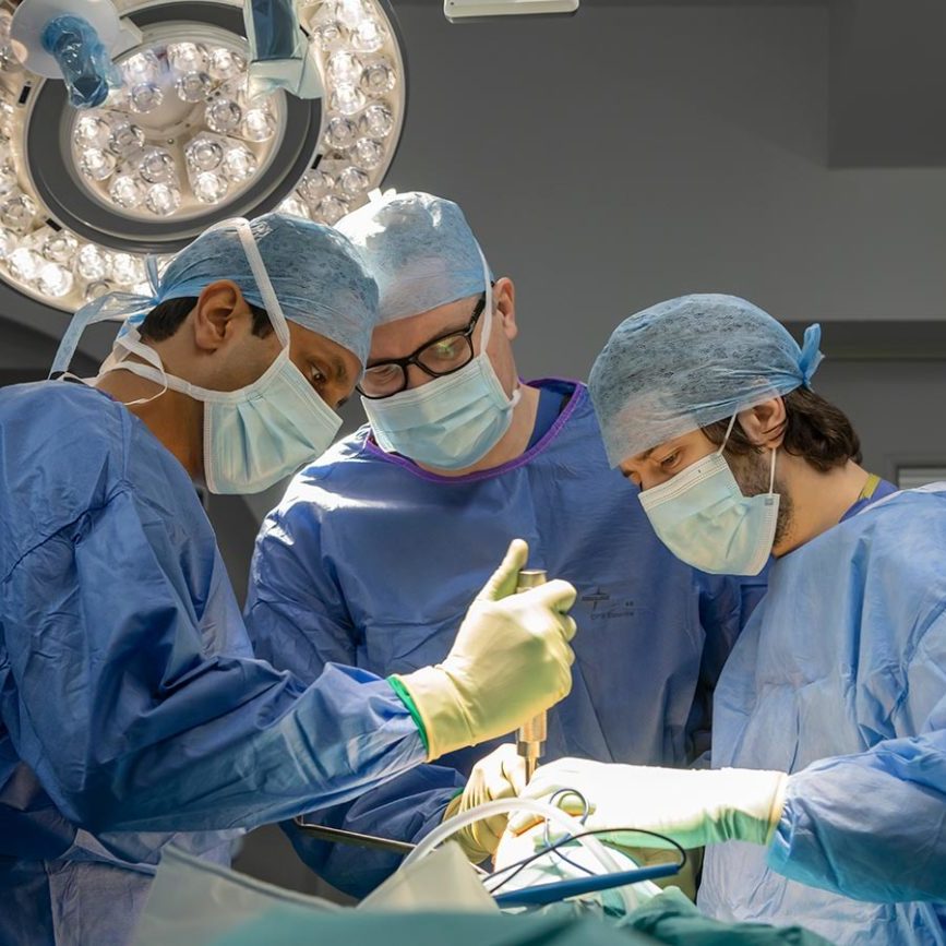 three surgeons operating